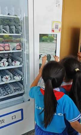 学生在积分兑换机前自助兑换奖品